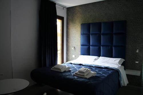 una camera da letto con un letto blu e asciugamani di Bamboo Luxury B&B a Agrigento