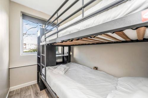 倫敦的住宿－Pass the Keys Whitechapel Central Apartment，一间卧室设有两张双层床和一扇窗户。