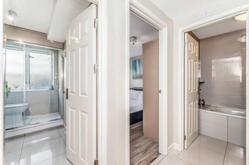 uma casa de banho com uma cabina de duche ao nível do chão e uma banheira em Pass the Keys Whitechapel Central Apartment em Londres