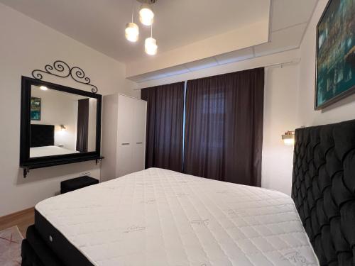 Un dormitorio con una cama blanca y un espejo. en Old Town Vip Apartment, en Novi Pazar
