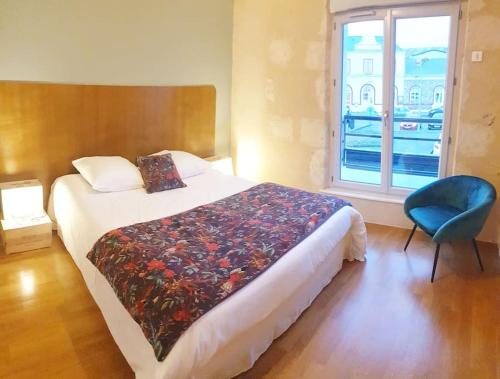 a bedroom with a bed and a blue chair and a window at La Stazione in Nogent-le-Rotrou