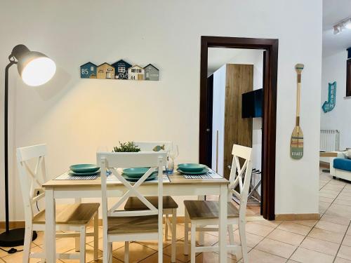 a dining room with a white table and chairs at Casa Saline in Tarquinia