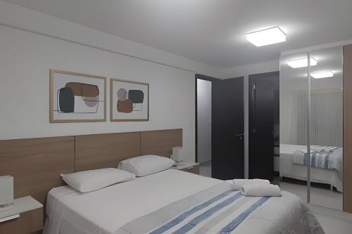 um quarto com uma cama grande e um espelho em Frente Mar Bessa João Pessoa em João Pessoa