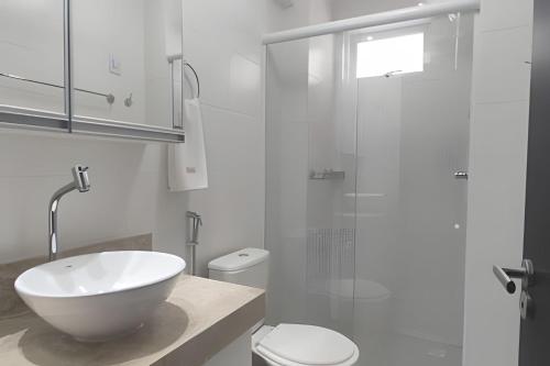 uma casa de banho branca com um lavatório e um WC em Frente Mar Bessa João Pessoa em João Pessoa