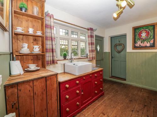 a kitchen with a sink and a red cabinet at Liberty House in Ashbourne