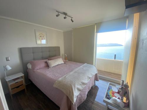 a bedroom with a bed with a view of the ocean at Costazul Playa la herradura in Coquimbo