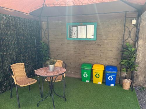 a table and chairs under a tent with three trash cans at Departamento Studio - Carrera - Factura - Central - Empresas - Parking - Wifi - Aire acondicionado in Chillán