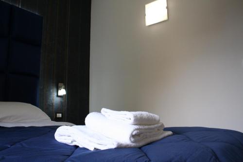 a pile of towels sitting on top of a bed at Bamboo Luxury B&B in Agrigento