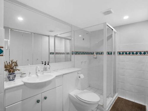 a white bathroom with a toilet and a sink at Gold Coast best holiday resort, perfect location ! in Gold Coast