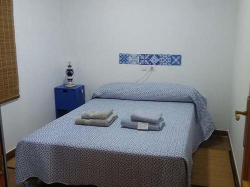 a bedroom with a bed with two towels on it at Albanta in Chipiona