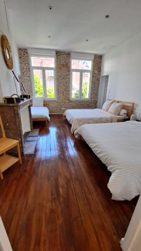 um quarto com 2 camas, uma lareira e pisos em madeira em Maison de charme, coeur de Douai em Douai