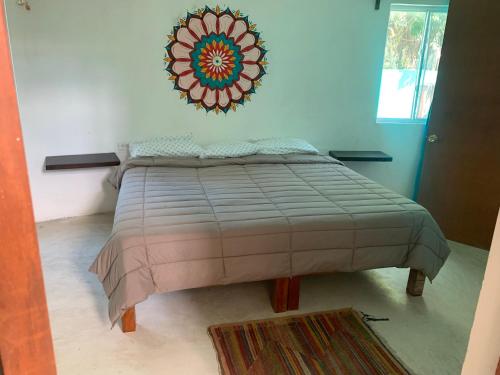a bed in a room with a mirror on the wall at Casa Redonda Hostal Inn 1 in Holbox Island