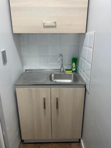 a small kitchen with a sink in a room at Departamento Studio - Carrera - Factura - Central - Empresas - Parking - Wifi - Aire acondicionado in Chillán