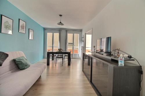 un salon avec un canapé, une télévision et une table dans l'établissement Studio Le Bourbon (31m²), à Bourges