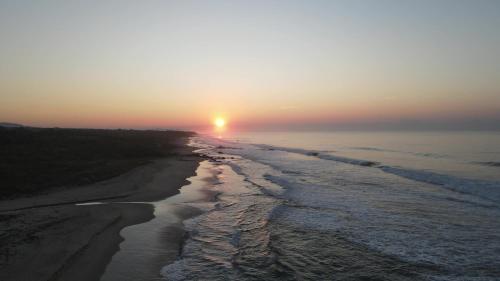 a sunset over a beach with the ocean at OCEAN OASIS HOTEL - adult only, four casitas boutique resort in Playa Agua Blanca