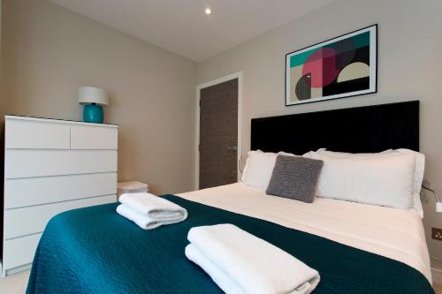 a bedroom with a bed with towels on it at Madison Hill - Fernlea Garden 8 - One bedroom home in London