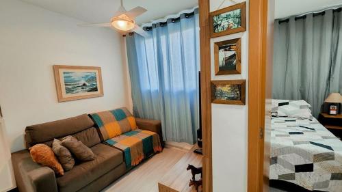 a living room with a couch and a bed at Apto 400m UEL, 2 quartos, ar condicionado egaragem in Londrina
