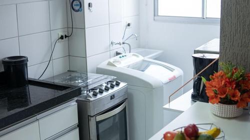 a white kitchen with a sink and a stove at Apto 400m UEL, 2 quartos, ar condicionado egaragem in Londrina