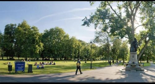 a person walking in a park with a statue at The Privacy Annex Balham in London