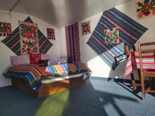 a room with a bed with colorful blankets on the wall at Uros Tupirmarka Lodge Perú in Puno