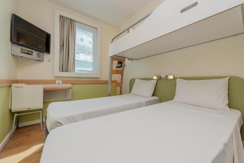 a hospital room with two beds and a tv at ibis budget Vitoria in Vitória