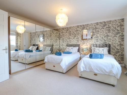 a bedroom with two beds and a large mirror at Hedgefield House in Grantham