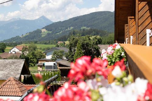a view of a mountain from a balcony with flowers at Pension Kärnten in Seeboden