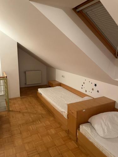 een slaapkamer met 2 bedden op een zolder bij J-Max in Bled