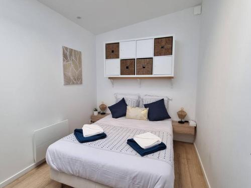 une chambre avec deux lits avec des oreillers bleus dessus dans l'établissement L'Emeraude Amiénoise Netflix/Hortillons/StLeu/Gare, à Amiens