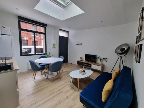 un salon avec un canapé bleu et une table dans l'établissement L'Emeraude Amiénoise Netflix/Hortillons/StLeu/Gare, à Amiens