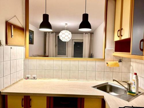 a kitchen with a sink and a mirror at YOURAPART ŚLISKA in Warsaw