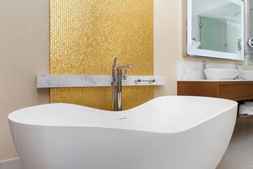 a bathroom with a white tub and a sink at Villa La Valencia Beach Resort & Spa Los Cabos in San José del Cabo
