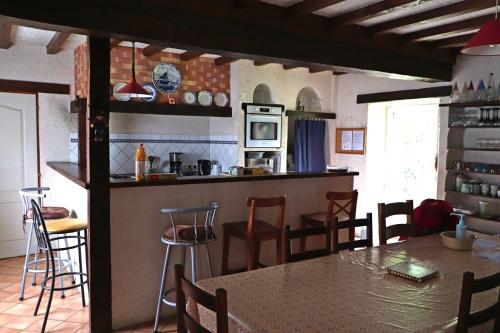 une cuisine et une salle à manger avec une table et des chaises dans l'établissement Corbon, à Vivoin