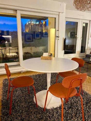 a table and chairs in a room with a window at Une vue les pieds dans l'eau in Metz