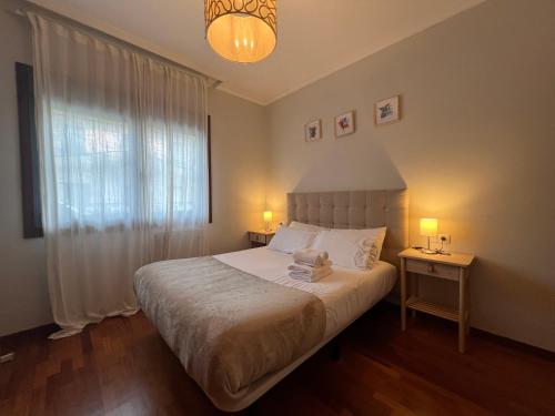 um quarto com uma cama com uma janela e 2 candeeiros em A estrenar ,con vistas al mar y aparcamiento gratis en el casco Viejo-Centro-Zona portuaria em Vigo