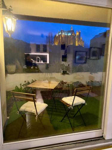 a window of a patio with a table and chairs at Une vue les pieds dans l'eau in Metz