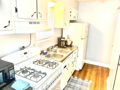 a white kitchen with a stove and a sink at Renasant Convention 5 mins-shuttle to down town- Regional One-UT Health-Methodist University-Lebonheur Hospital in Memphis