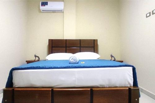 ein Schlafzimmer mit einem Bett mit einer blauen Decke darauf in der Unterkunft Céntrico Estudio Cruceño A/C 2 in Santa Cruz de la Sierra