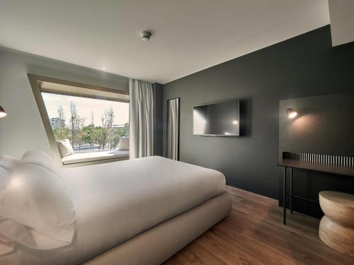Un dormitorio con una gran cama blanca y una ventana en Hotel SB Win en Sant Feliu de Llobregat