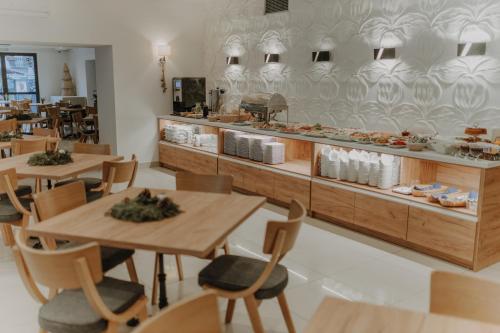 restauracja z drewnianymi stołami i krzesłami oraz ladą w obiekcie Parkowe Szczyrk w Szczyrku