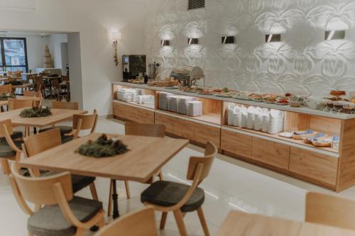 a restaurant with wooden tables and chairs and a counter at Parkowe Szczyrk in Szczyrk