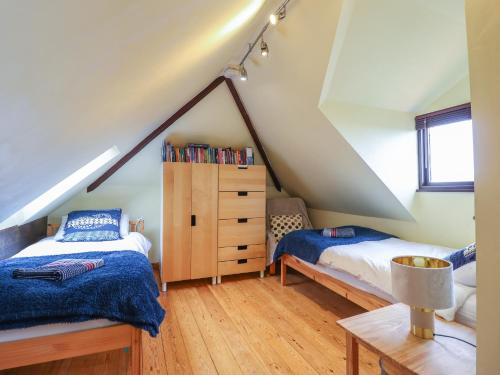 a attic bedroom with two beds and a dresser at Highgate in Llandudno