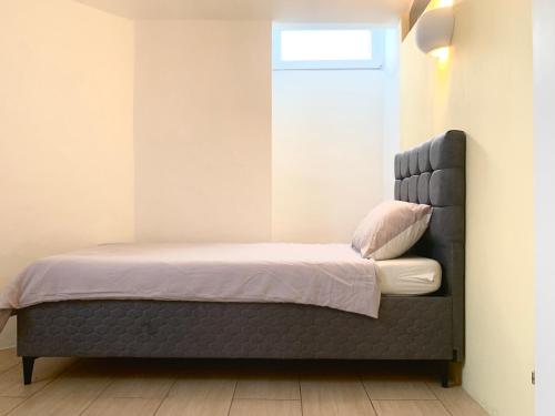 Bett mit schwarzem Kopfteil in einem Zimmer in der Unterkunft Centrally located Apartment Vienna included Netflix in Wien