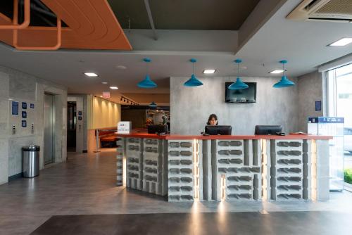 a woman sitting at a counter in an office at ibis budget Vitoria in Vitória