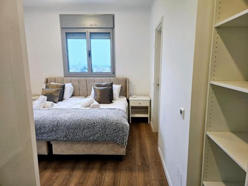 Dormitorio pequeño con cama y ventana en וגאס en Bayit Wegan