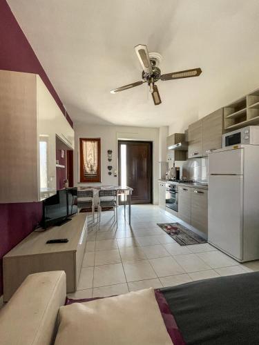 a living room with a ceiling fan and a kitchen at La Piazzetta in Torella deʼ Lombardi