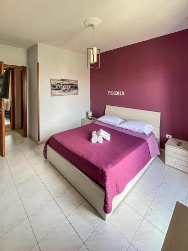 a bedroom with a large bed with purple walls at La Piazzetta in Torella deʼ Lombardi