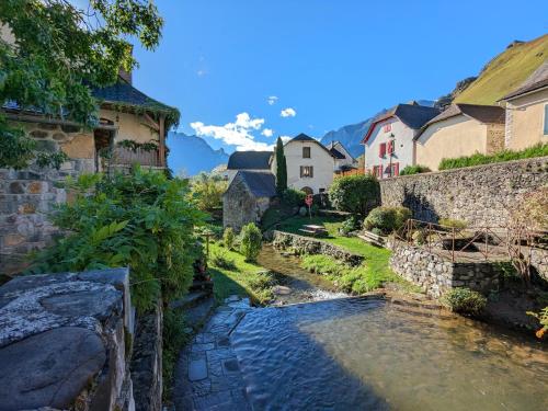 a stream in a village with houses and buildings at Gîte XIIIème siècle - 3 étoiles - WIFI - Salle de sport in Osse-en-Aspe