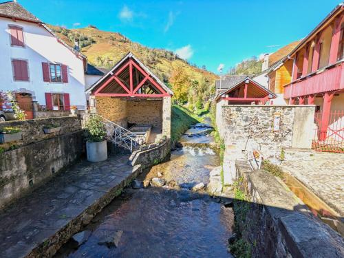 a river in a village with houses and buildings at Gîte XIIIème siècle - 3 étoiles - WIFI - Salle de sport in Osse-en-Aspe