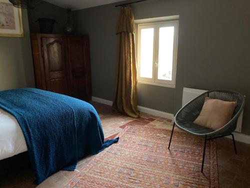 a bedroom with a bed and a chair and a window at Casa 55 in Tulette